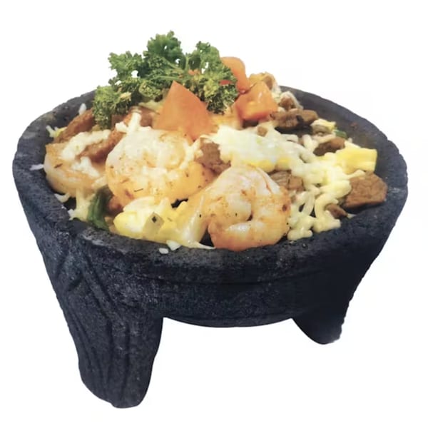 Palacio Maya's Molcajete with shrimp, meat, cheese, and vegetables in a traditional stone bowl.